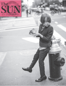 Cover of The Sun May 2024 issue, featuring a black and white photo of a child in a suit leaning on a fire hydrant with a piece of bread in his hands.