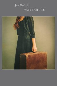 Cover of Wayfarers by Jane Medved, featuring a photograph of a woman from the neck down with red hair wearing a green dress holding a large brown suitcase.